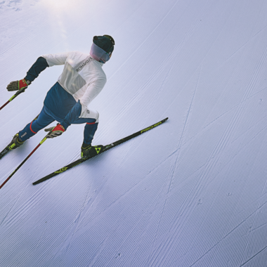 Ein Skifahrer fährt auf einer perfekt präparierten Piste. Die klare, schneebedeckte Umgebung strahlt Ruhe und Konzentration aus.