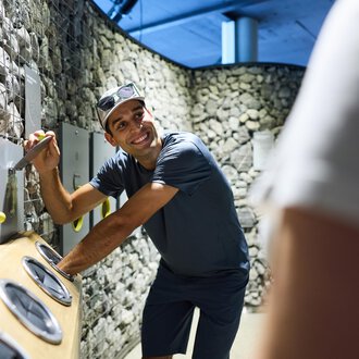 Ein moderner Flur mit großen Wandbildern und einem offenen Empfangsbereich. Die Wände sind mit sanften Farben und schönen Landschaften gestaltet. | © Kleinwalsertal Tourismus | Oliver Farys
