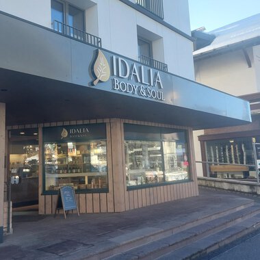 A store with the sign "IDALIA BODY & SOUL" is visible. It is designed in a modern style and has large windows that provide a view inside. | © IDALIA | S. Lorenz