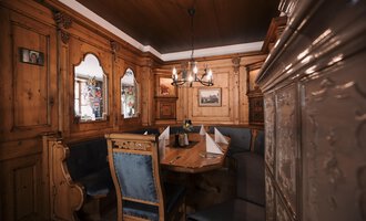 Ein gemütliches Interieur mit Holzwänden und einem großen Tisch. Die Einrichtung ist traditionell und einladend.