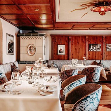An elegant restaurant with wood paneling and stylish tables. The cozy atmosphere is enhanced by the decorative pictures and tasteful furnishings. | © Hotel Birkenhöhe | Sascha Gast