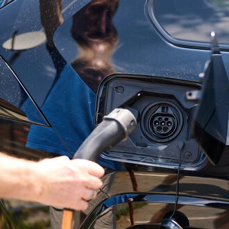 An electric car is being charged. A charging cable is plugged into the charging port. | © Kleinwalsertal Tourismus | Oliver Farys