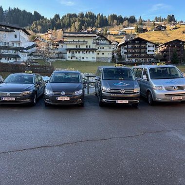 Zwei Taxis stehen vor einem Wohnhaus. Das schwarze Taxi und das weiße Kombi-Taxi sind bereit für Fahrgäste. | © Walser Taxi | Josef Düringer
