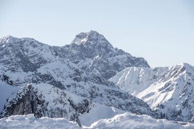 Panoramablick auf den verschneiten Widderstein-Gipfel und umliegende Berge in winterlicher Landschaft. | © Kleinwalsertal Tourismus eGen • Fotograf: Dominik Berchtold