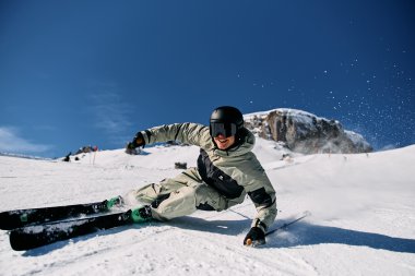 Skier skier falling in the snow on a ski slope under a clear blue sky. | © Kleinwalsertal Tourismus eGen • Photographer: Oliver Farys