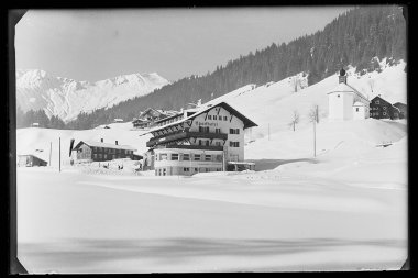 Schneebedecktes Sporthotel Walsertal in Baad mit umgebenden Bergen und traditionellem Gebäude, Aufnahme in Schwarzweiß. | © Kleinwalsertal Tourismus eGen • Karl Max Kessler Archiv
