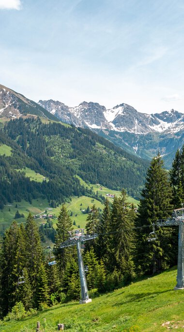 Mountain station of a cable car in the Alps with mountains, forests, and a ski lift in Oberstdorf, Germany. | © Oberstdorf · Kleinwalsertal Bergbahnen