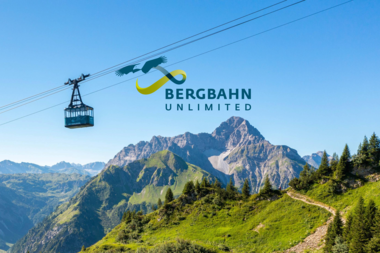 Seilbahn mit Berggipfeln im Hintergrund, Logo von Bergbahn Unlimited im Himmel