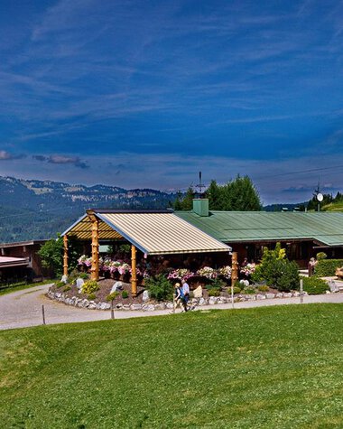 Bergstüble im Kleinwalsertal mit grüner Wiese, blauer Himmel und umliegende Berge, im Sommer bei gutem Wetter. | © Kleinwalsertal Tourismus eGen
