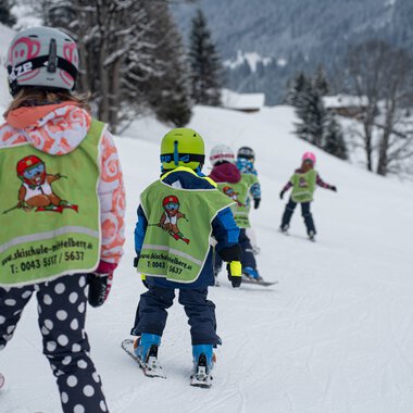 Children in ski lessons learning to ski on a snowy slope with instructors and parents in Mittelberg. | © Skischule Mittelberg