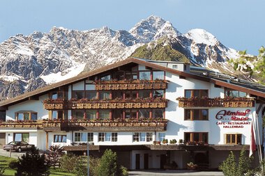Das Hotel Almhof Rupp mit mehreren Balkonen und einer Bergkulisse im Hintergrund. | © Almhof Rupp