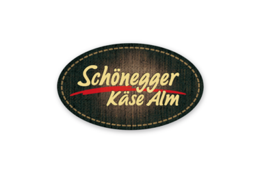 Das Logo von Schönegger Käse Alm, oval mit dunklem Hintergrund und gelber, roter und weißer Schrift. | © Schönegger Käsealm