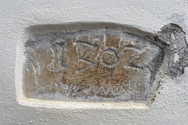 Alter Stein mit eingeschnittenem Text 'IZBOZ' und unleserlichen Zeichen, in eine Wand eingelassen. | © Kleinwalsertal Tourismus eGen